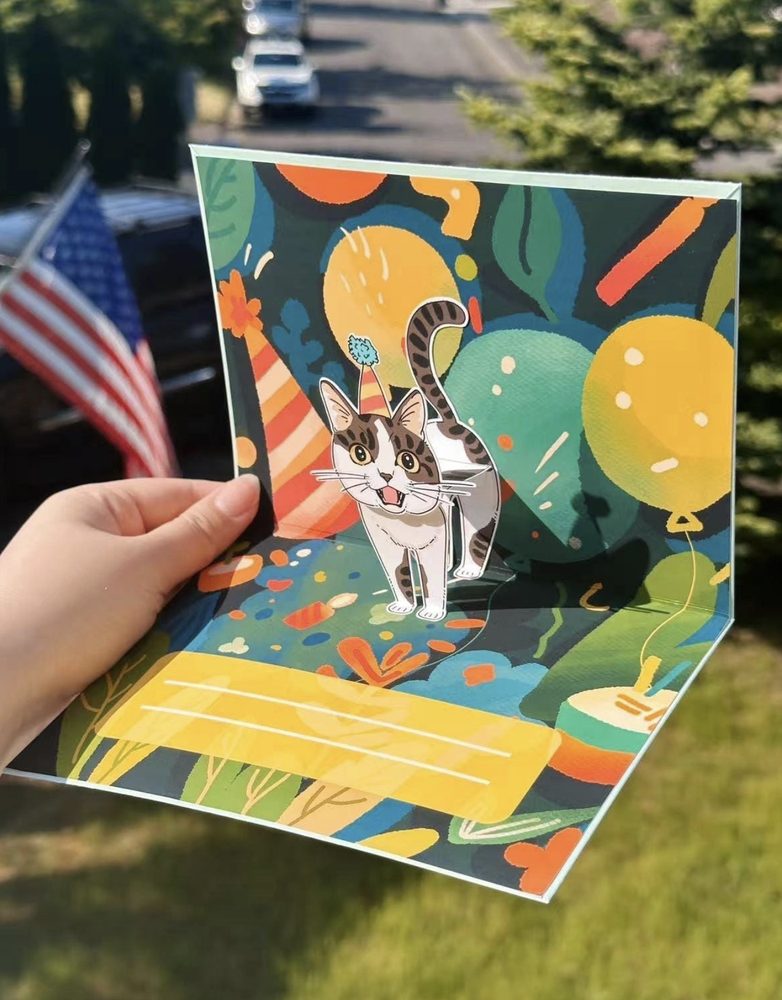 Cat pop-up birthday card opened, with a tabby cat standing among balloons and leaves